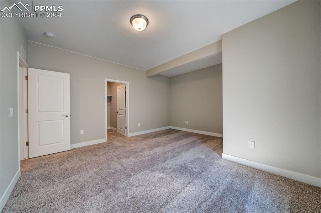 Image 23 of 47: Unfurnished bedroom with light colored carpet, a closet, and a walk in clos