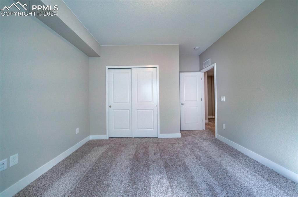 Image 27 of 47: Unfurnished bedroom with carpet floors and a closet