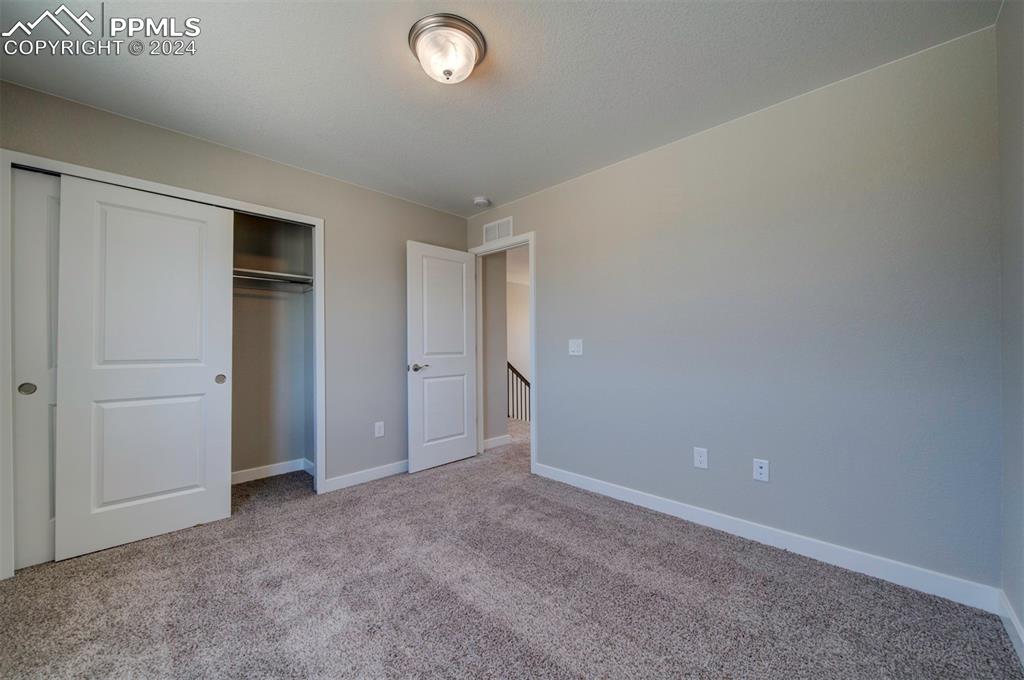 Image 28 of 47: Unfurnished bedroom with a closet and light colored carpet