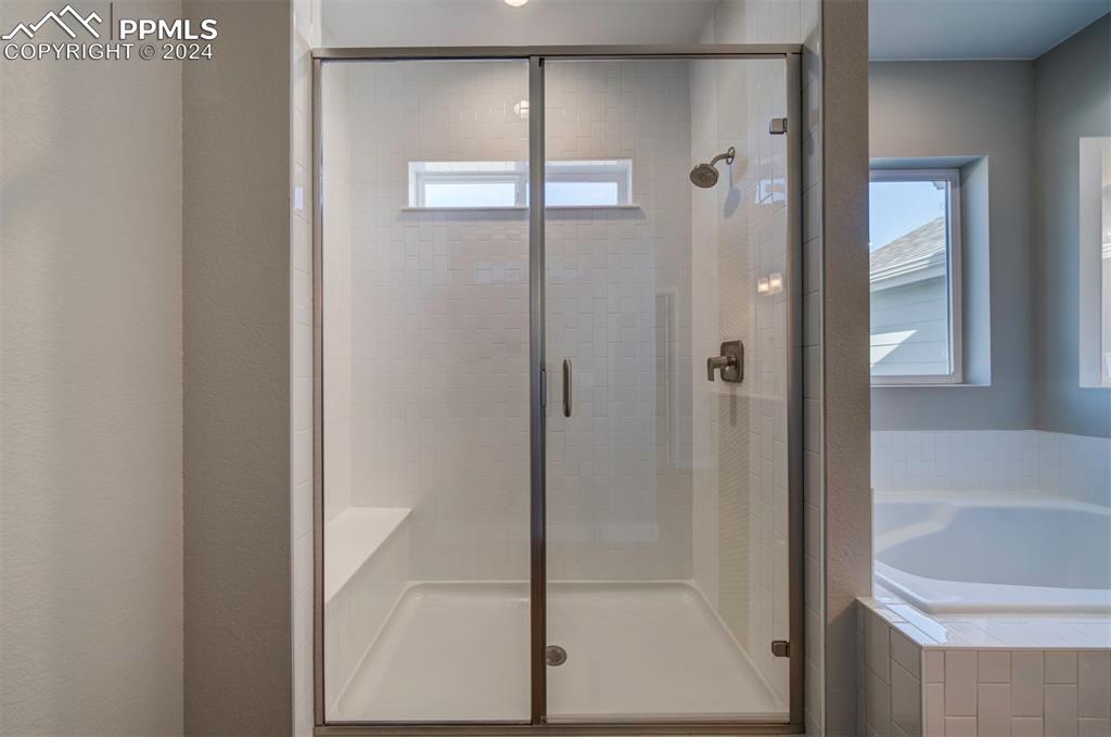 Image 30 of 47: Bathroom featuring shower with separate bathtub and a healthy amount of sun