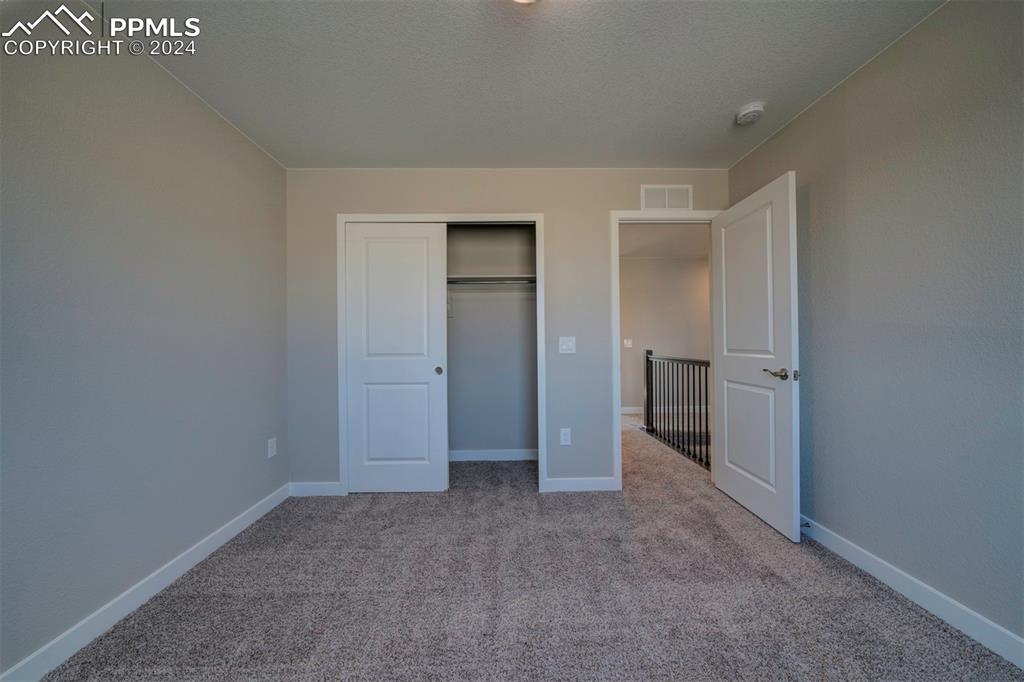 Image 32 of 47: Unfurnished bedroom with light carpet and a closet