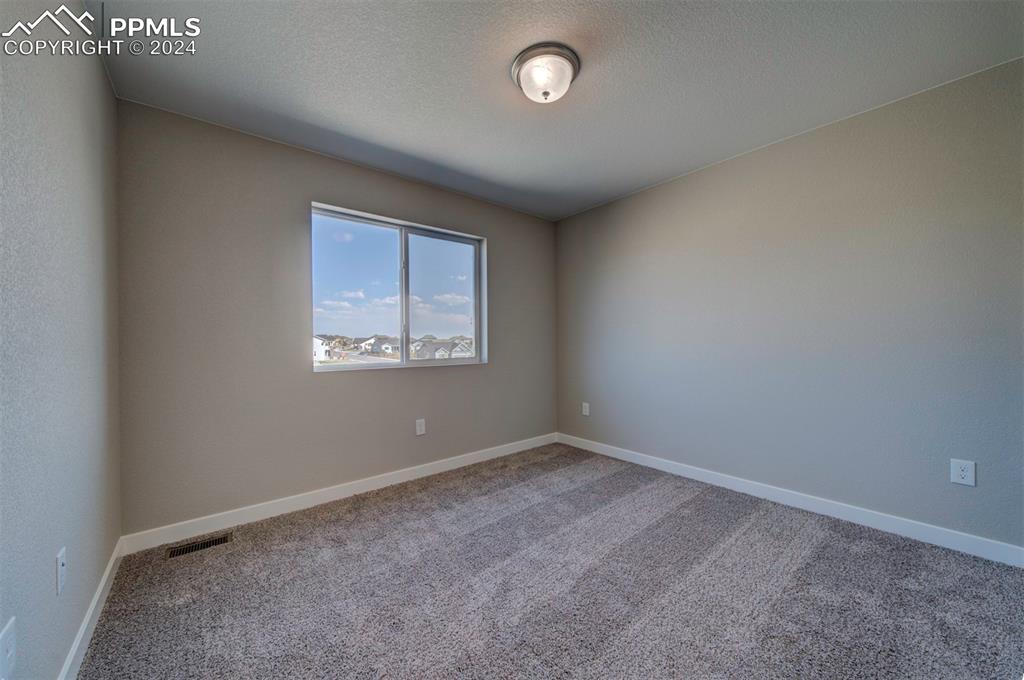 Image 34 of 47: Empty room with carpet and a textured ceiling