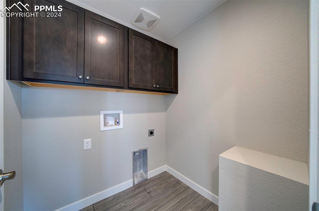 Image 35 of 47: Clothes washing area with hardwood / wood-style floors, cabinets, hookup fo