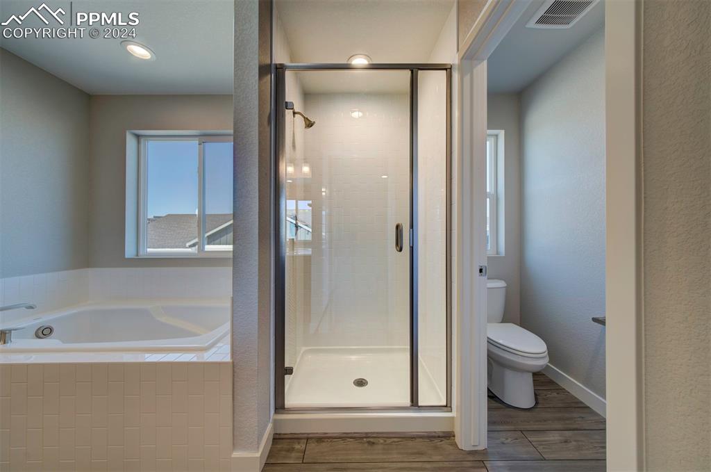 Image 37 of 47: Bathroom featuring toilet, plus walk in shower, and wood-type flooring