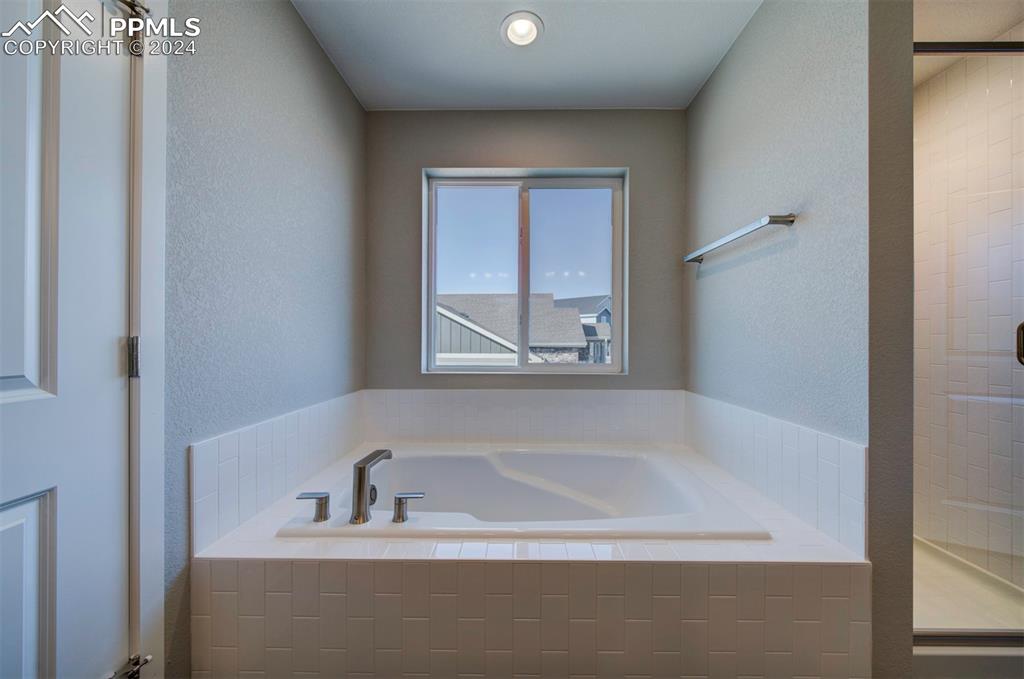 Image 38 of 47: Bathroom featuring tiled bath