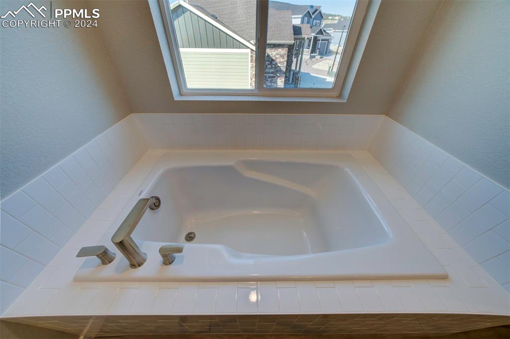 Image 41 of 47: Bathroom featuring a relaxing tiled tub