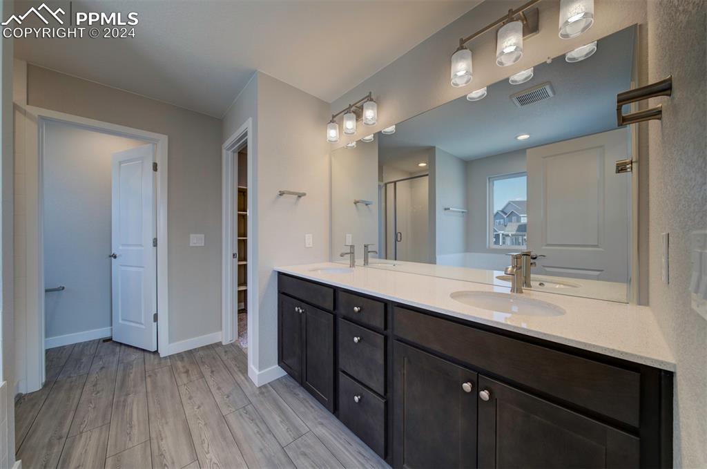 Image 42 of 47: Bathroom featuring double sink vanity and wood-type flooring