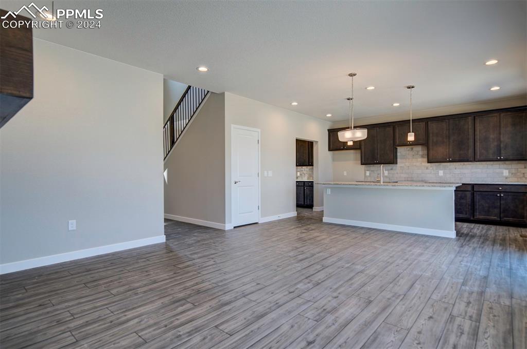 Image 8 of 47: Kitchen featuring dark brown cabinetry, light hardwood / wood-style floors,