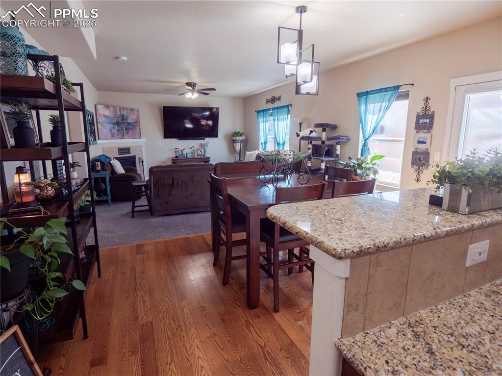 Image 13 of 32: Kitchen with light stone countertops, dark wood-style floors, a fireplace, 