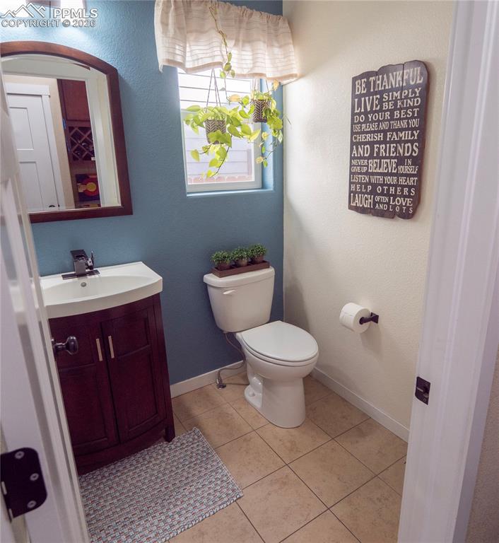 Image 14 of 32: Bathroom featuring vanity, light tile patterned floors, and a textured wall