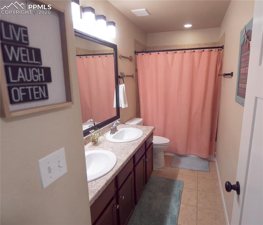 Image 20 of 32: Full bathroom featuring double vanity and light tile patterned floors