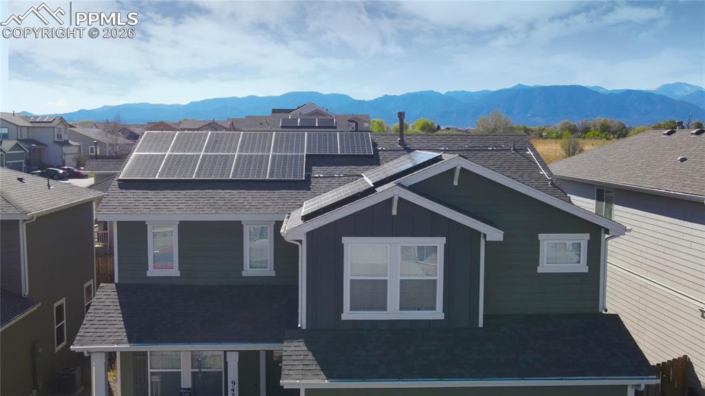 Image 31 of 32: Front of property with roof mounted solar panels, a mountain view, a shingl
