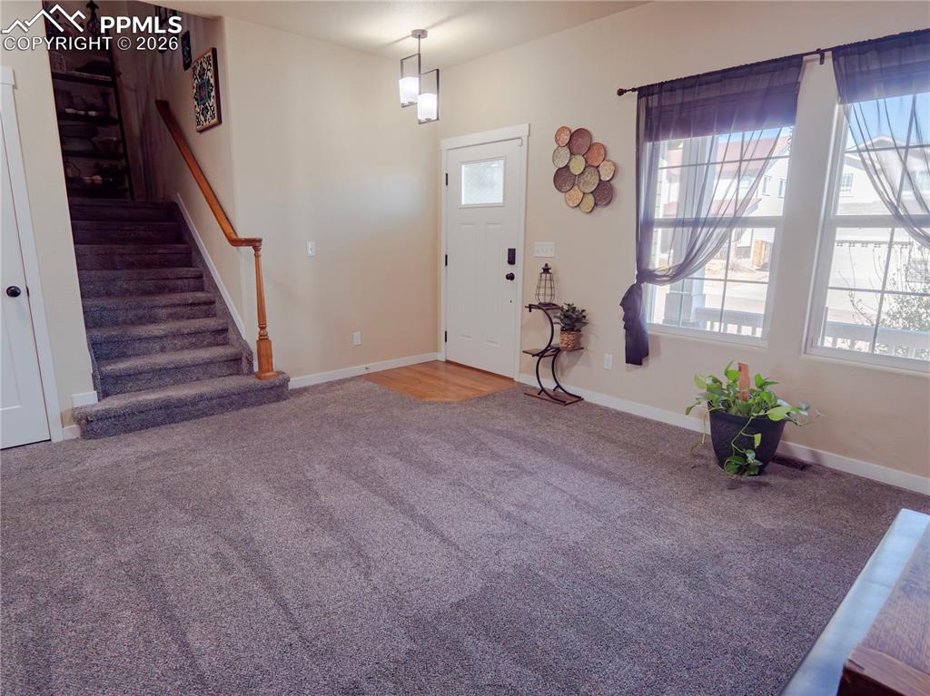 Image 6 of 32: Foyer with stairway and carpet floors