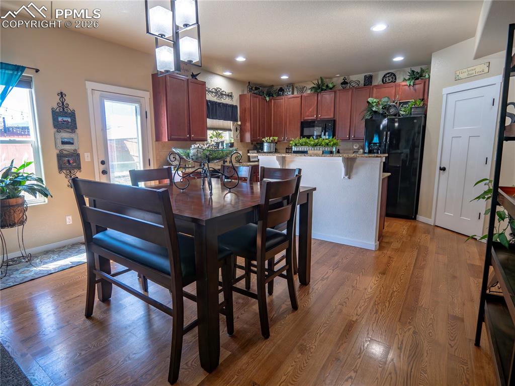 Image 9 of 32: Dining area with dark wood finished floors and recessed lighting