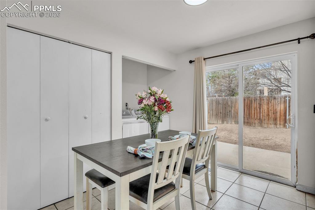 Image 12 of 44: Dining area with light tile patterned floors and washer / dryer