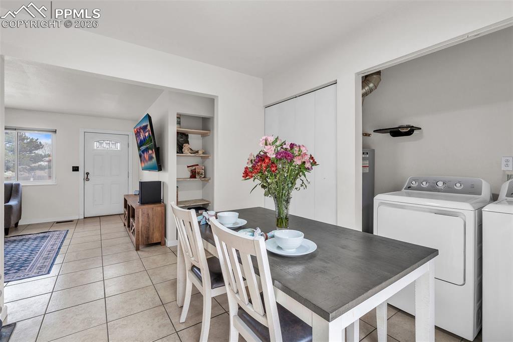 Image 13 of 44: Dining area featuring light tile patterned floors, washer and clothes dryer