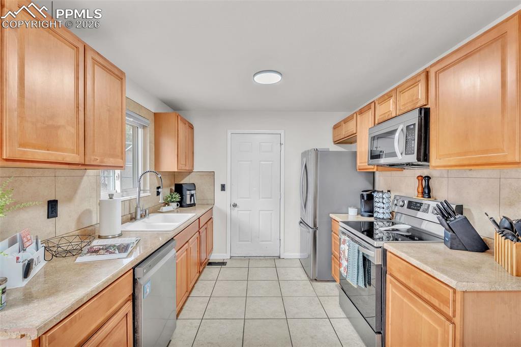 Image 16 of 44: Kitchen featuring stainless steel appliances, backsplash, light countertops