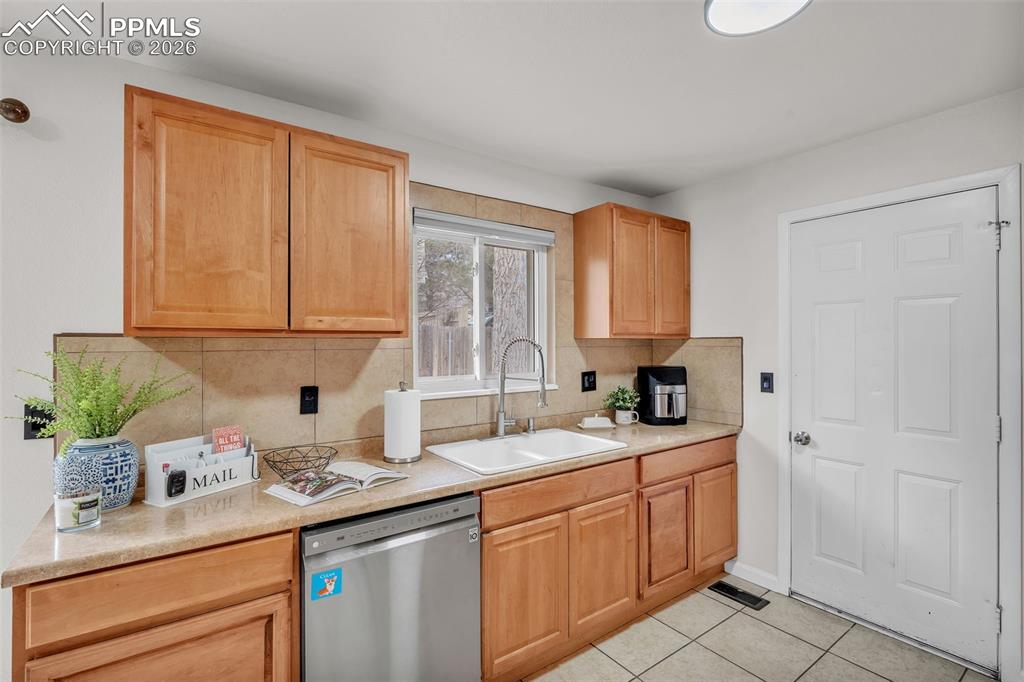 Image 17 of 44: Kitchen featuring tasteful backsplash, dishwasher, and light countertops
