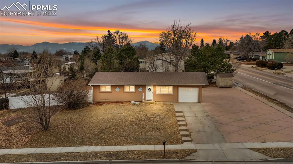 Image 2 of 44: Single story home featuring concrete driveway, a garage, stucco siding, roo