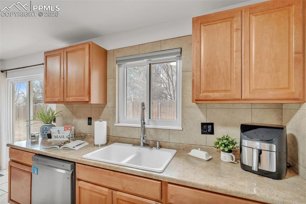 Image 20 of 44: Kitchen featuring dishwasher, light countertops, and plenty of natural ligh