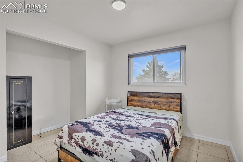 Image 21 of 44: Bedroom with baseboards and light tile patterned floors