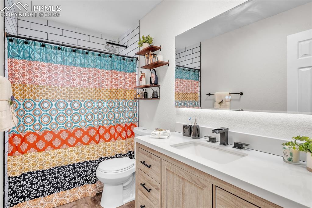 Image 24 of 44: Bathroom with vanity and curtained shower