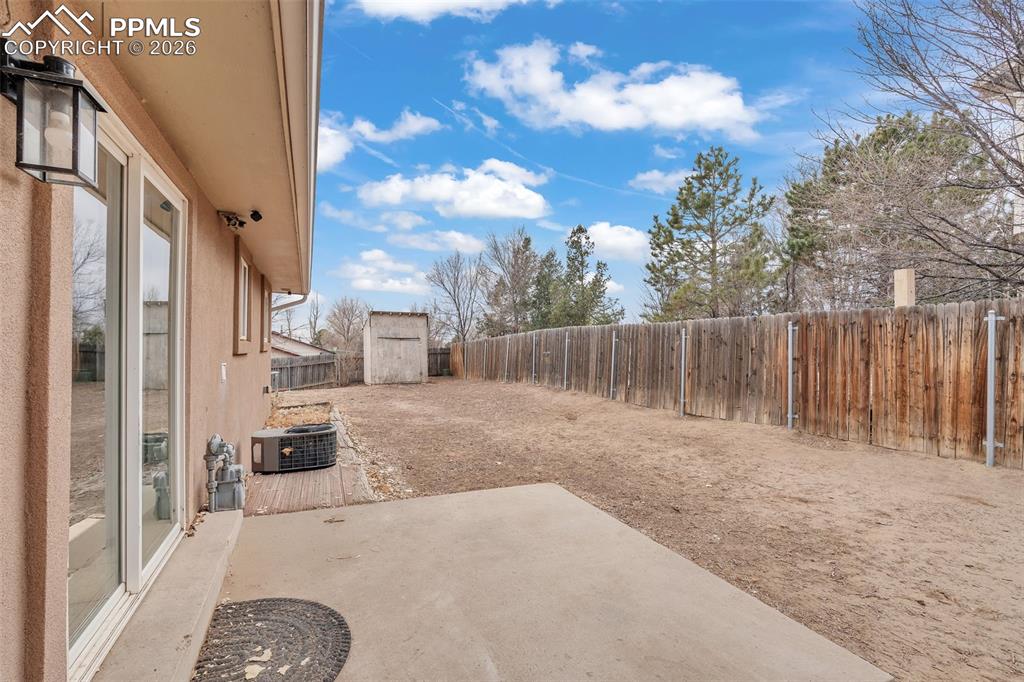 Image 34 of 44: Fenced backyard featuring a patio and a shed