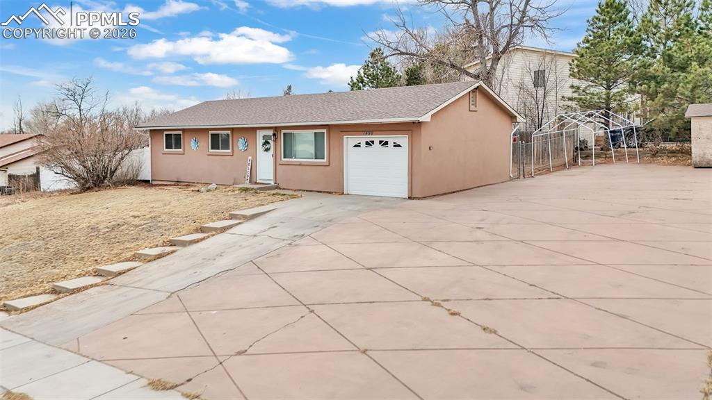 Image 4 of 44: Ranch-style house with stucco siding, driveway, an attached garage, and a s