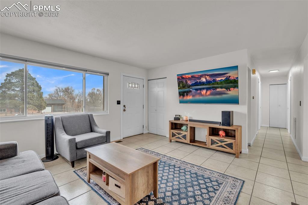 Image 9 of 44: Living area with light tile patterned floors and baseboards