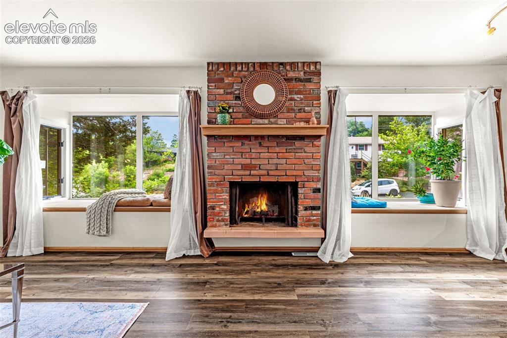 Image 13 of 38: Brick fireplace with a wood-finish mantel and hearth