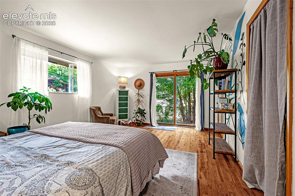 Image 17 of 38: Spacious room featuring wood-finish flooring, white walls, and a large wind