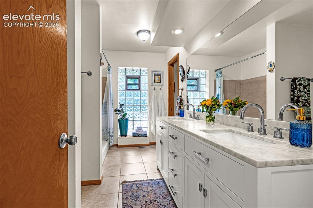 Image 18 of 38: Double vanity with a light stone countertop and undermount sinks