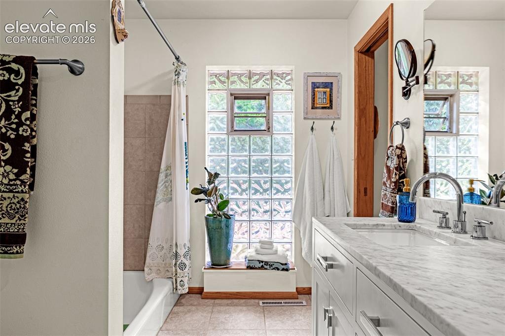 Image 19 of 38: Bathroom featuring a white vanity with an undermount sink and a stone count