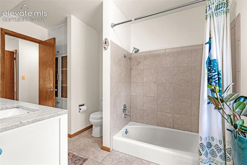 Image 22 of 38: Bathroom featuring a tub/shower combination with light-toned tiled surround
