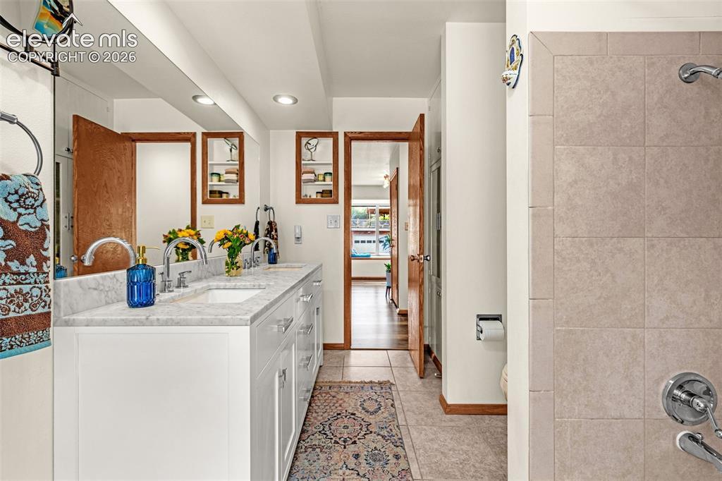 Image 24 of 38: Dual sink vanity with white cabinetry and a light-toned countertop