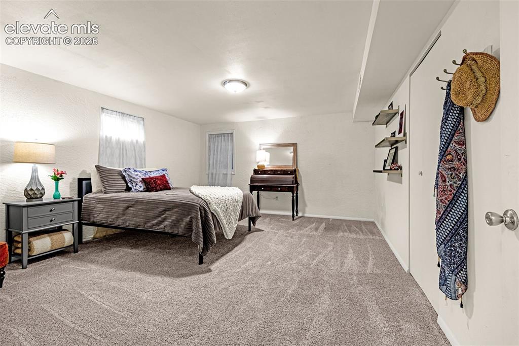 Image 29 of 38: Spacious room featuring light-colored textured walls, soft neutral carpetin