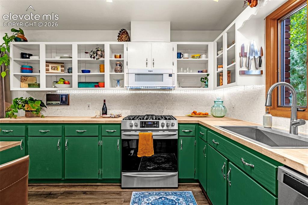 Image 6 of 38: Updated kitchen featuring wood-finish countertops, two-tone cabinetry, a st
