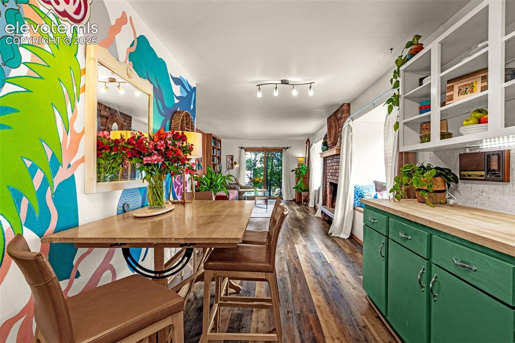 Image 8 of 38: Open-concept living area featuring wood-finish flooring, a wood-top breakfa