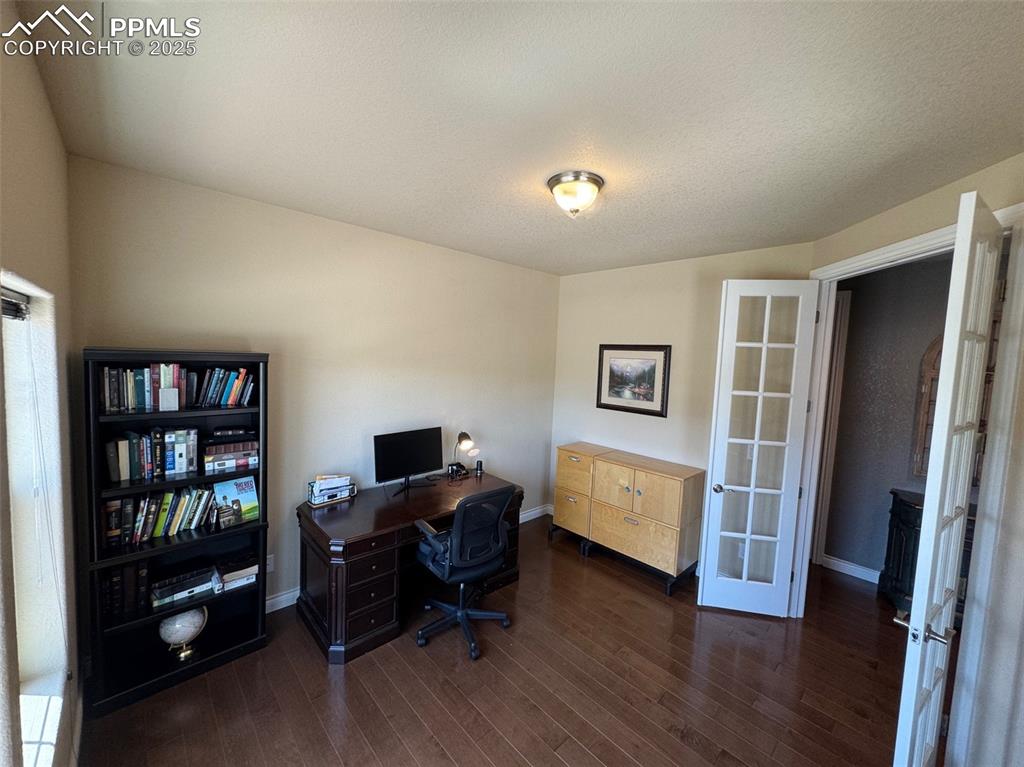 Image 5 of 40: Office space featuring dark wood-style flooring and french doors