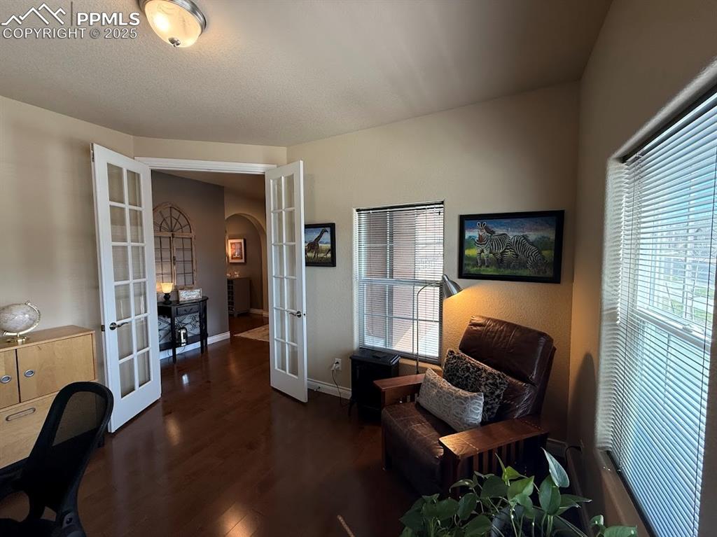 Image 6 of 40: Office or bedroom area with arched walkways, french doors, baseboards, and