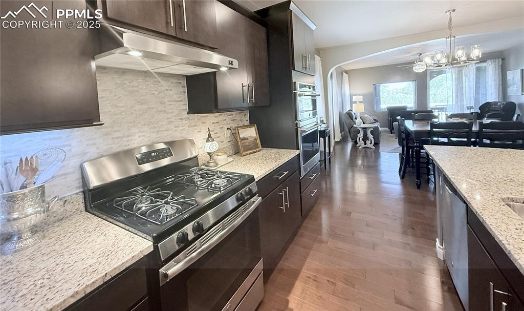 Image 7 of 40: Kitchen with appliances with stainless steel finishes, under cabinet range