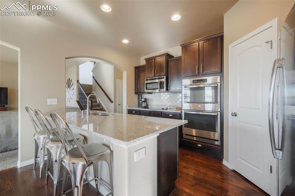 Image 10 of 50: Kitchen with stainless steel appliances, granite counters, double wall oven