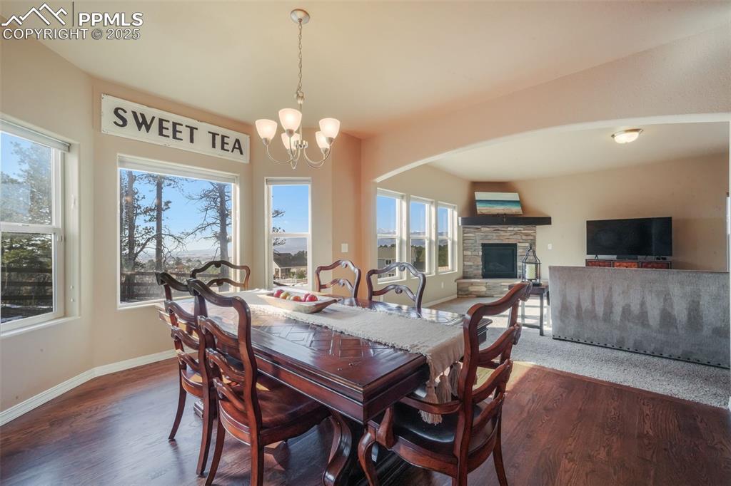 Image 12 of 50: Dining area with hardwood floors, access to back patio and mountain views