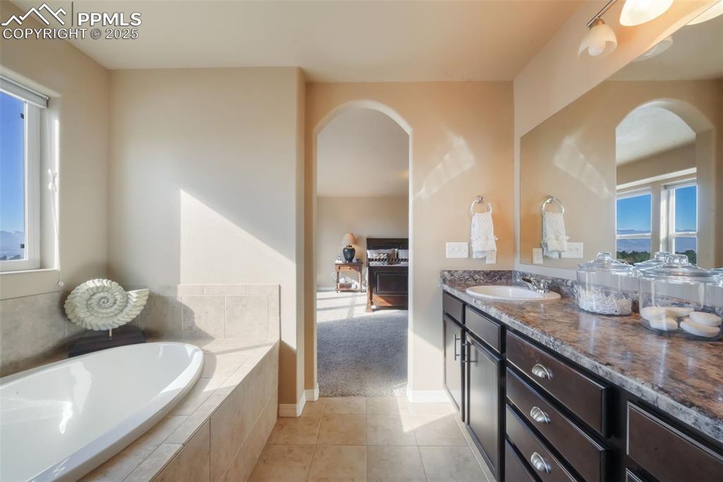 Image 24 of 50: Primary bathroom with dual vanities, soaking tub, large shower, and walk in
