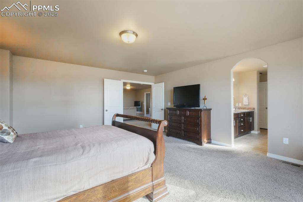 Image 26 of 50: Upstairs primary bedroom with French doors