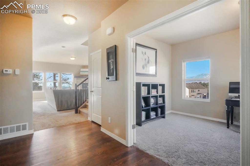 Image 3 of 50: Hardwood entry with access into main floor office with mountain views