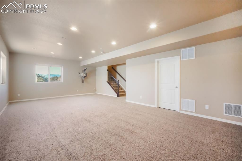 Image 39 of 50: Basement family room with garden level window showcasing mountain views