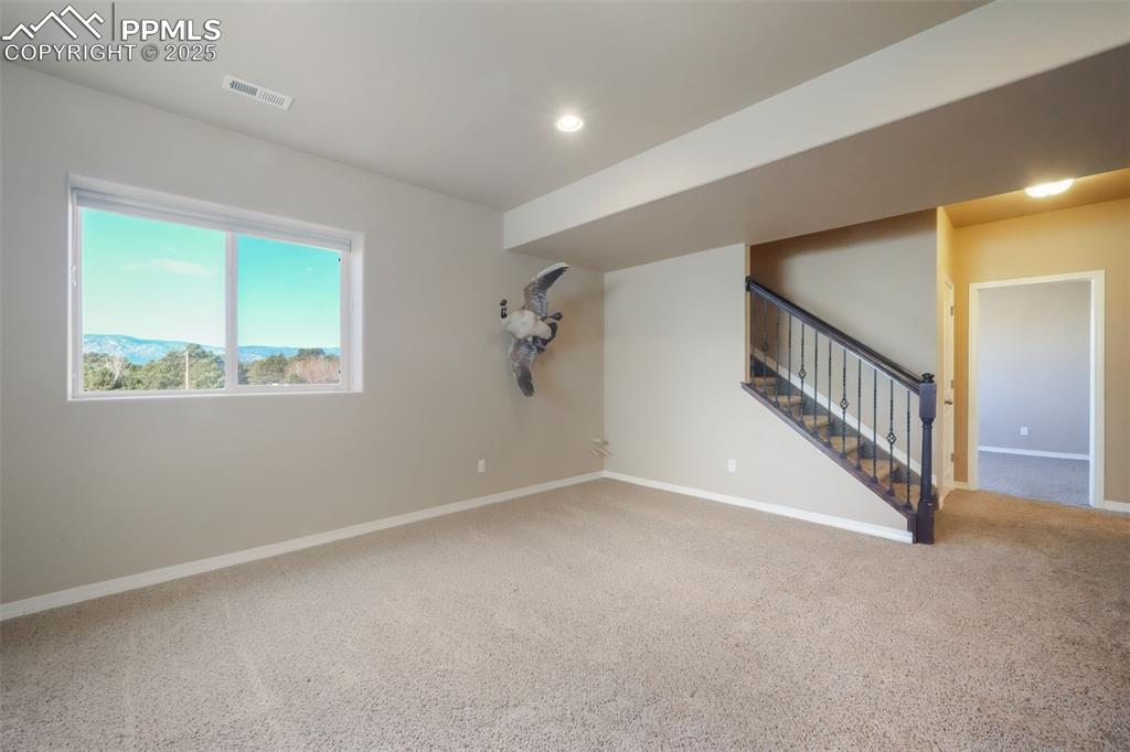 Image 40 of 50: Basement family room with garden level window showcasing mountain views