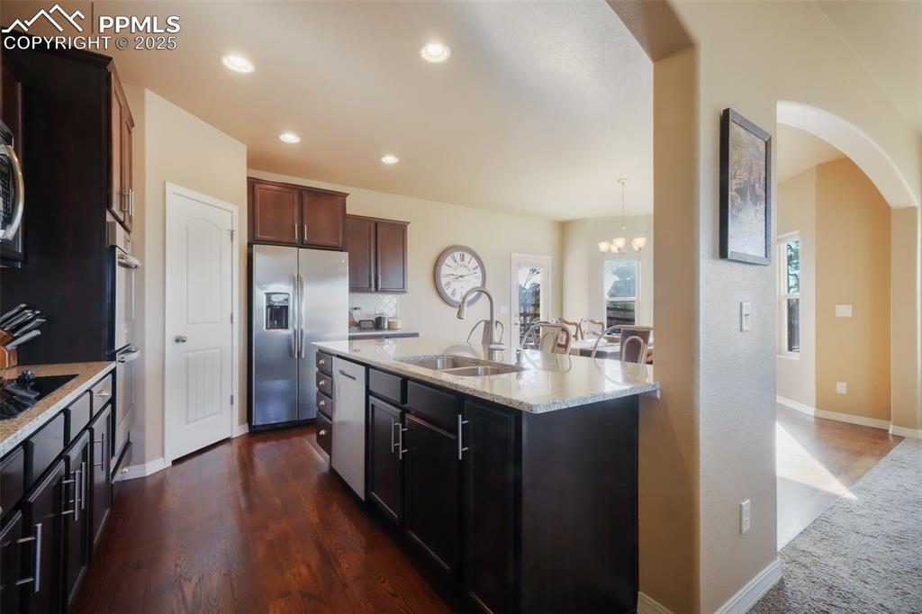 Image 6 of 50: Kitchen with stainless steel appliances, granite counters, double wall oven