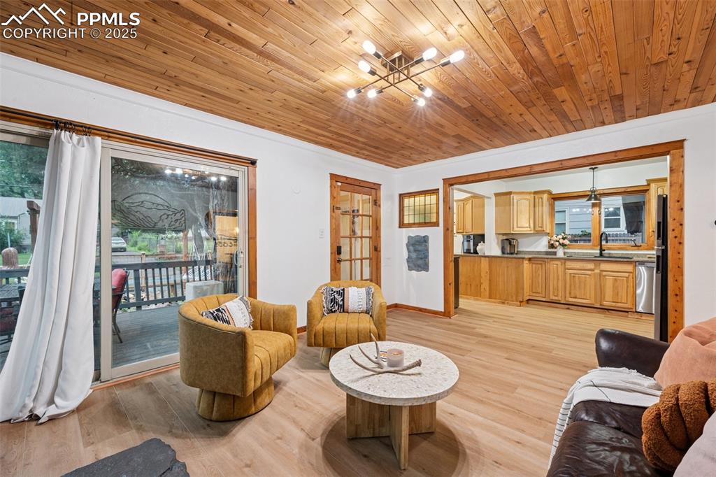 Image 10 of 48: Living room featuring a chandelier, wood ceiling, light wood-style flooring
